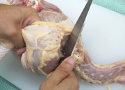 包丁の刃元を使って手羽もとの関節に包丁入れ筋を切り、肩甲骨に沿って包丁を入れ肉を切り離す